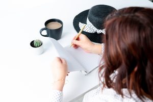 a stock image of a woman writing in a journal photographed by style shoot social